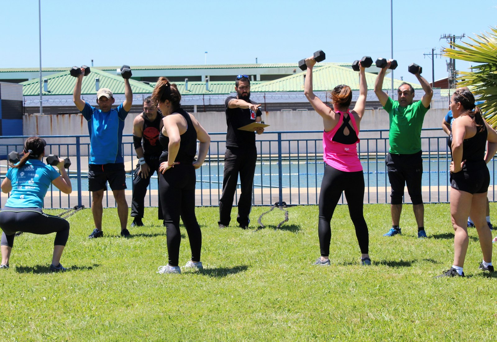 A group enjoying outdoor exercise with dumbbells on the grass