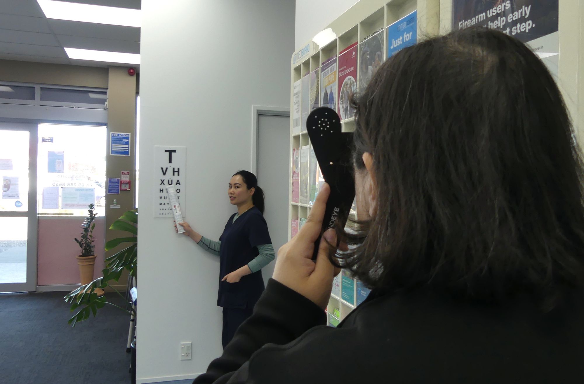 Jane pointing to the eye chart while a patient covers one eye