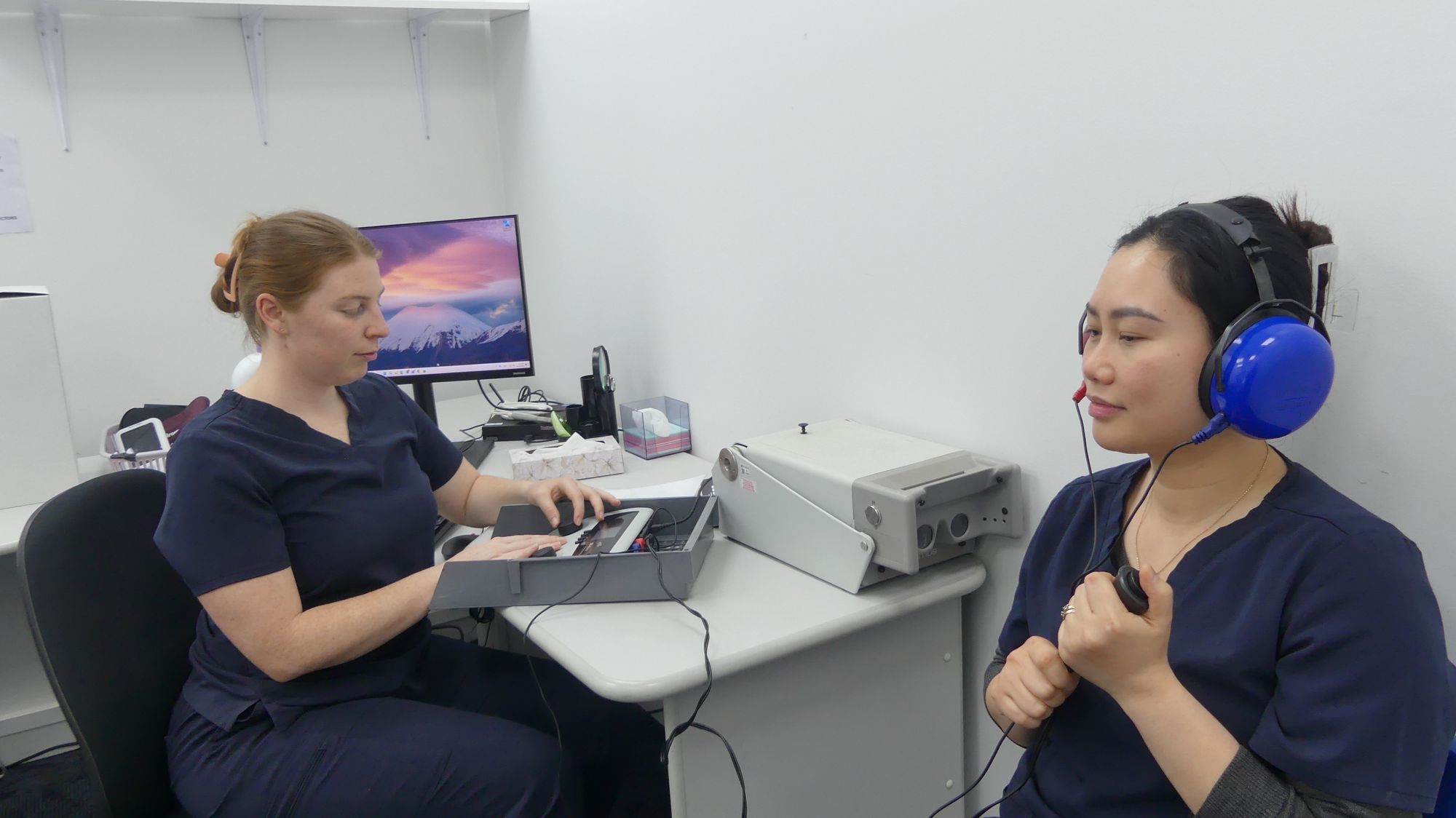 Nurse Maddy running a hearing test for a patient wearing headphones