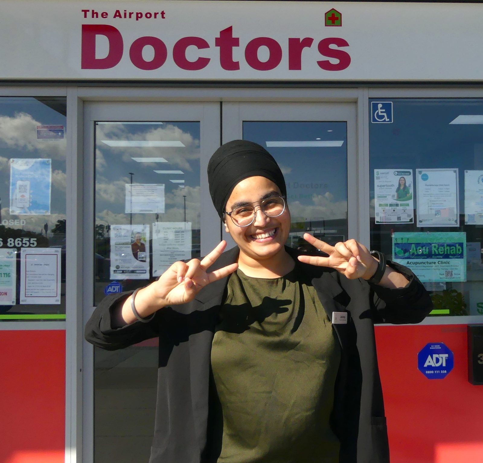 Jasdeep flashing peace signs outside the clinic