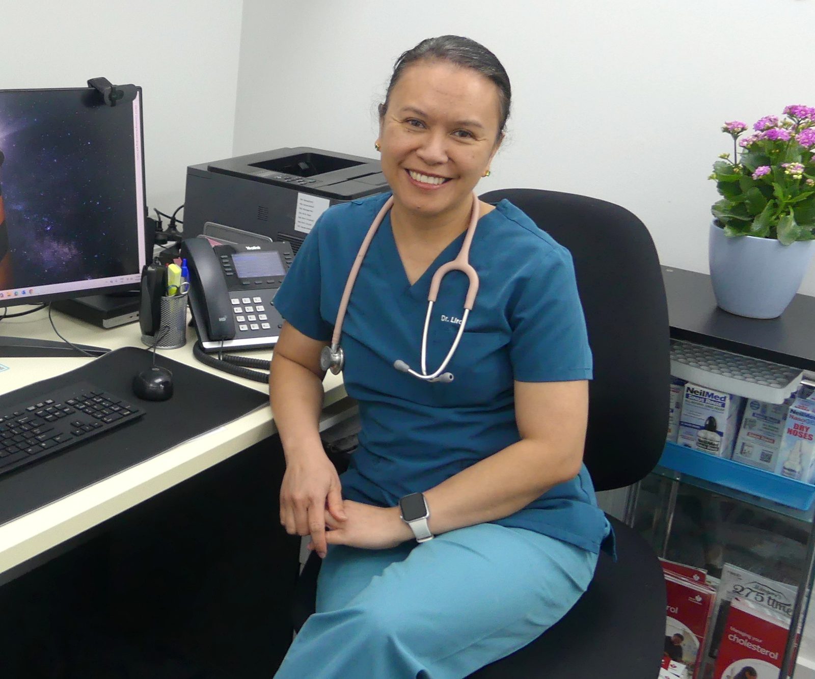 Dr Lira Lecias smiling at her desk